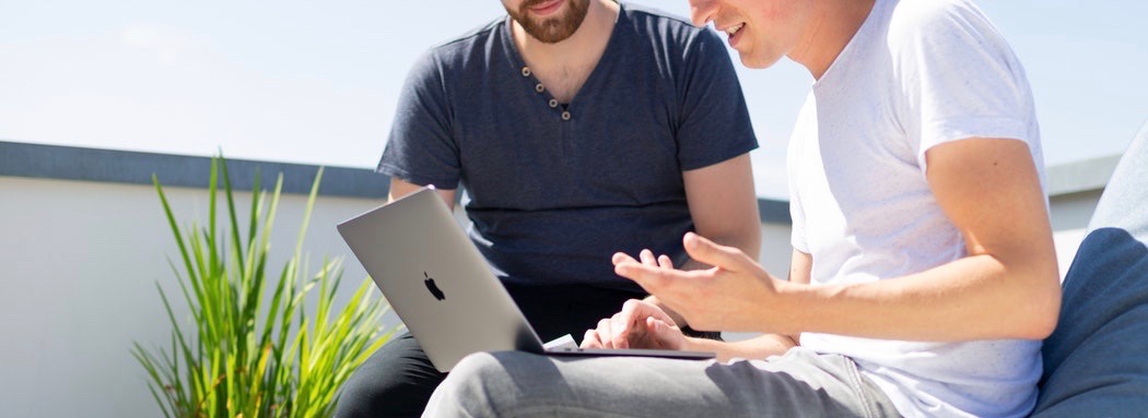 Deux jeunes hommes avec un ordinateur portable.